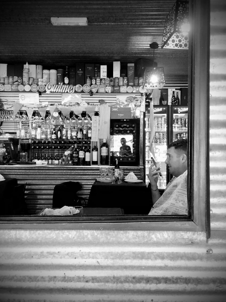 La barra vista desde la ventana, con botellas y luz baja